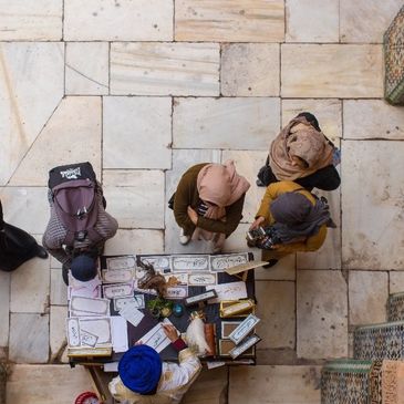 A group of people sitting around on the ground.